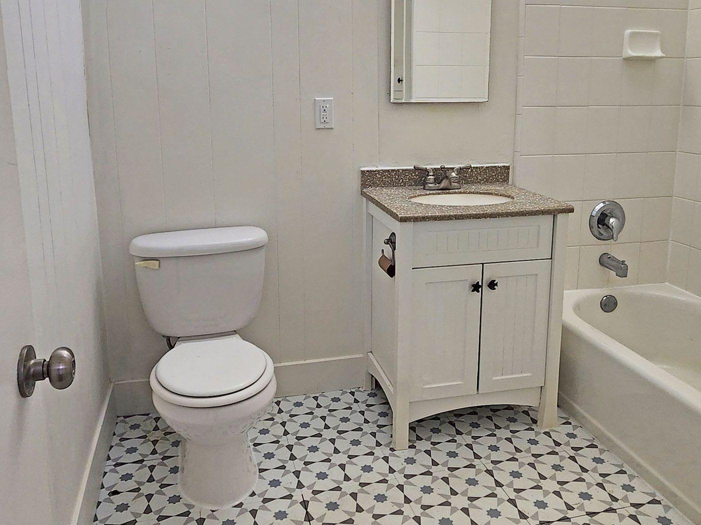 A bathroom with a patterned tile floor