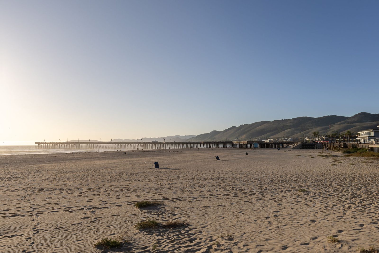 Pismo State Beach at sunset, looking north along the sand to the Pismo Pier and the hills behind
