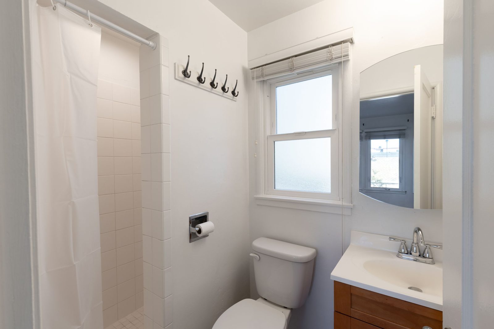 The bathroom in Apartment 1 with a shower, a vanity and a frosted window