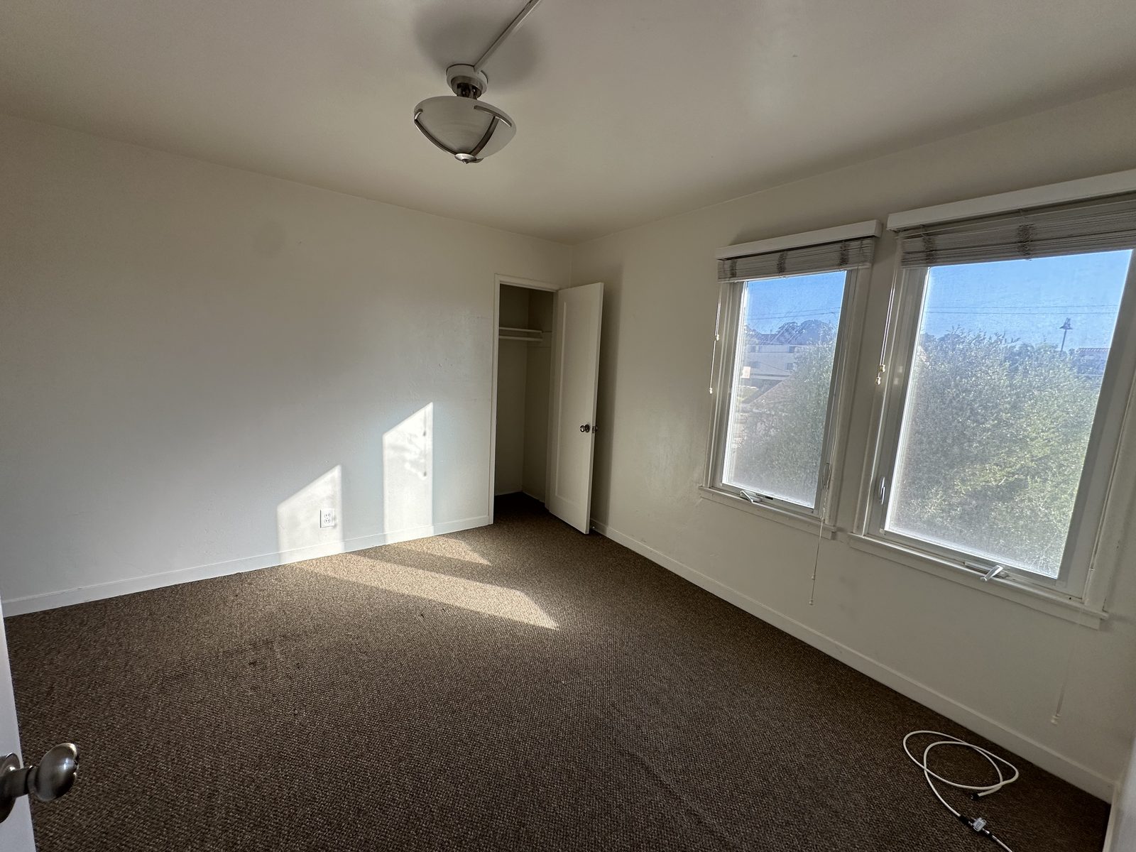 A bedroom in Apartment 2 with a closet and two windows