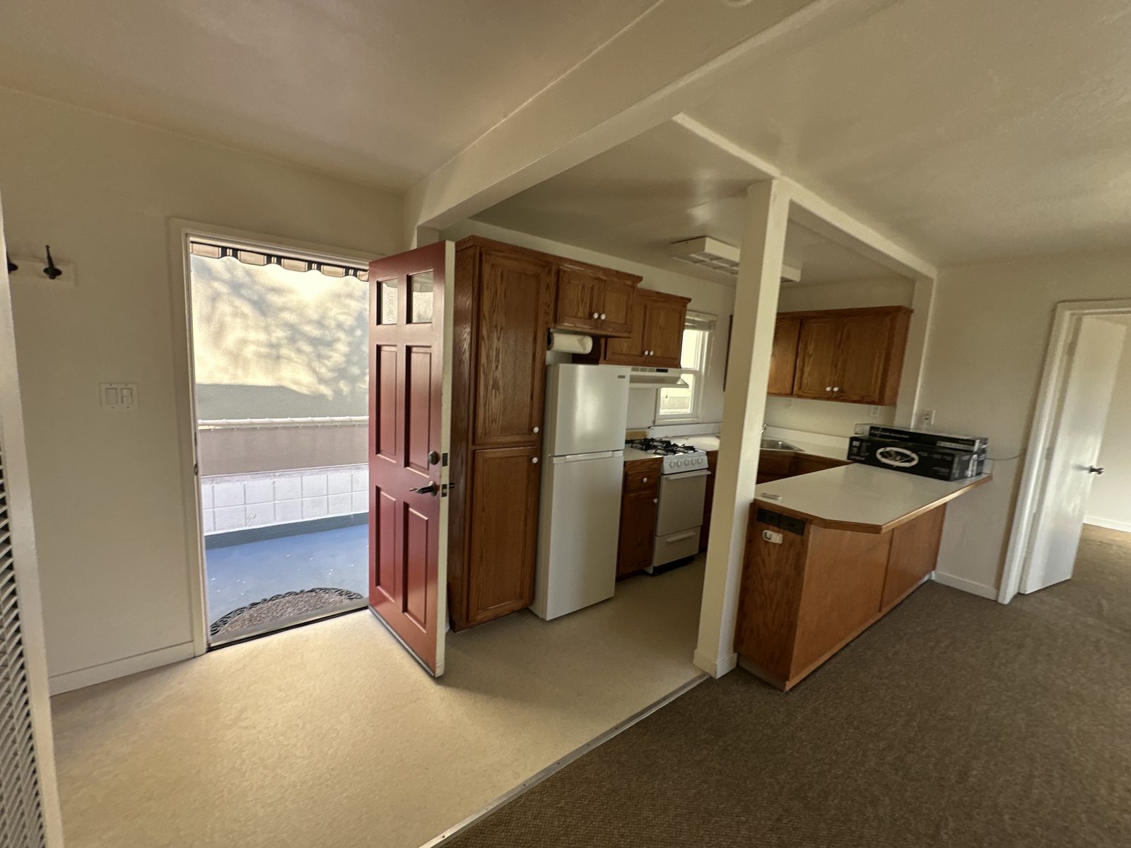 The entry to Apartment 2, with the red front door open onto the deck walkway
